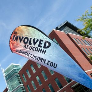 Close up of a flag with the text "Get involved at UConn. UConntact.UConn.edu."